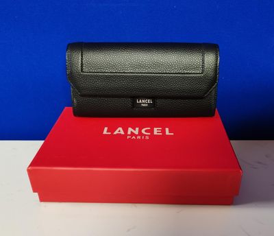 a black and red box sitting on top of a table next to a blue wall