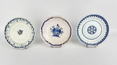 three blue and white plates with designs on them on a white surface