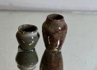 two vases that are sitting on a glass table