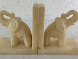 two elephant bookends sitting on a white table