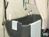 une baignoire au milieu d'une salle de bains, d'où pendent des serviettes