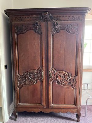 a large wooden armoire in the corner of a room
