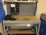 un établi dans un garage, sur lequel sont posés de nombreux outils