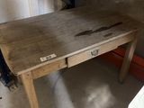 a wooden desk with a drawer underneath it in a garage