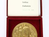 an image of a gold medal in a red box on a white surface