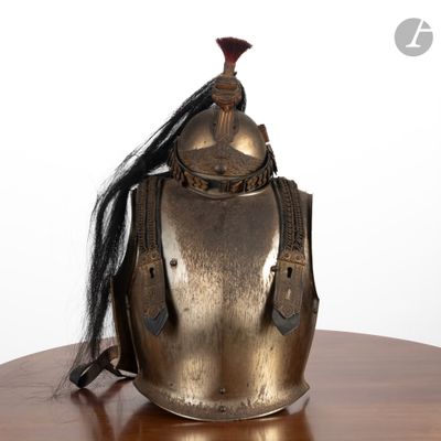 un casque métallique posé sur une table en bois, avec une longue mèche de cheveux noirs