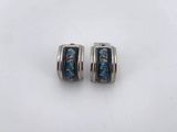 a pair of blue and silver earrings on a white surface