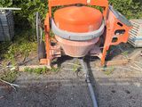 une bétonnière orange garée sur le bord de la route