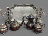 a silver tray with a silver tea set on top of it