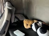 a stuffed panda bear sitting on a bench in the back of a van
