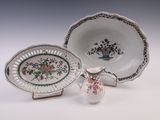 une assiette blanche ornée d'un motif floral, à côté d'un bol et d'une assiette ornée d'un motif floral