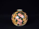 un petit vase orné de fleurs sur fond noir