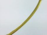 un bracelet plaqué or avec un motif en peau de serpent