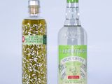 deux bouteilles d'huile d'olive et une bouteille d'huile d'olive posées sur une surface blanche