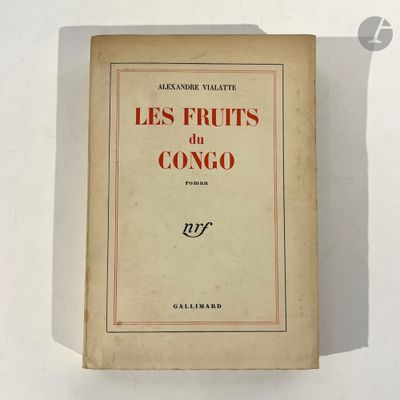 an old book on a white table with a red and black cover