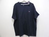 a black t - shirt hanging on a hanger on a wall