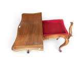 a small wooden table with a red cushion on it