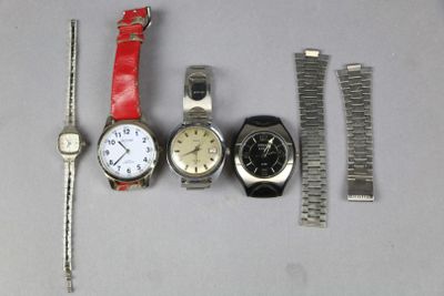 trois montres et un bracelet de montre sont posés les uns à côté des autres
