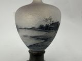a vase with a painting on it sitting on a table