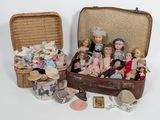 a lot of dolls sitting in a suitcase on the floor
