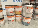 many cans of paint sitting on a table in a store