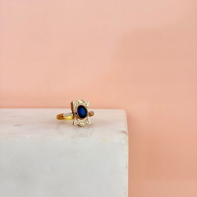 an image of a gold ring with a blue stone in the middle of it