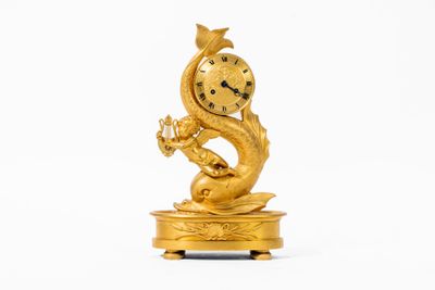 une horloge en or posée sur un socle orné d'un dragon