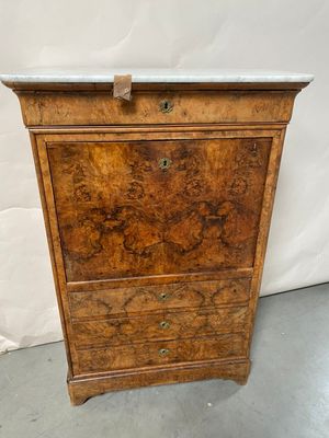 an old wooden chest of drawers with a marble top
