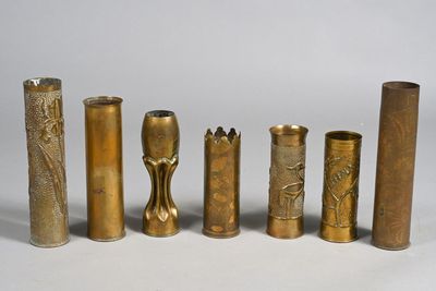 quatre vases en laiton de styles différents posés sur une surface blanche