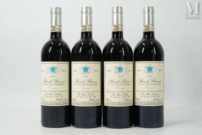 four bottles of wine are lined up on a white surface