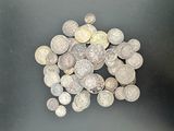 a pile of silver coins on a black surface