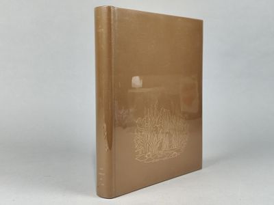 un vieux livre posé sur une table à côté d'un mur blanc