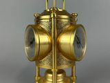 a gold clock that is sitting on a stand
