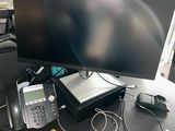 a desk with two monitors, a phone and a laptop on it