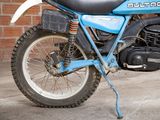 a blue motorcycle parked in front of a brick wall