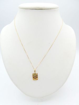 a white mannequin with a gold plated necklace and a gold plated necklace with a gold plate