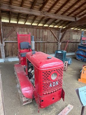 un tracteur rouge garé dans une grange