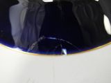 a blue plate with a gold rim on a white table