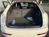 a white car with its trunk open in a parking lot
