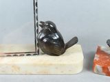 two birds that are sitting on top of a piece of marble