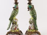 un couple de perroquets verts sur une branche ornée de fleurs et de feuilles