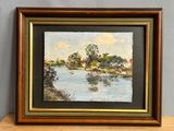 Tableau à l'huile encadré représentant une scène fluviale avec des maisons au loin
