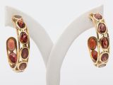 an image of a pair of gold and garnet stone hoop earrings