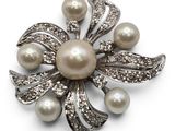 an image of a brooch with pearls and diamonds on a white background