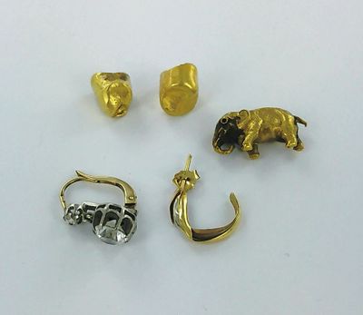three gold and silver jewelry pieces on a white surface