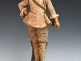 figurine représentant un homme avec un chapeau et une canne