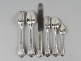 five forks, a knife, and a spoon on a table