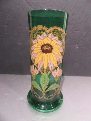 un vase vert orné d'une fleur jaune et rose