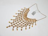 gros plan d'un collier en or sur fond blanc