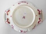 a white plate with red flowers on it on a white surface